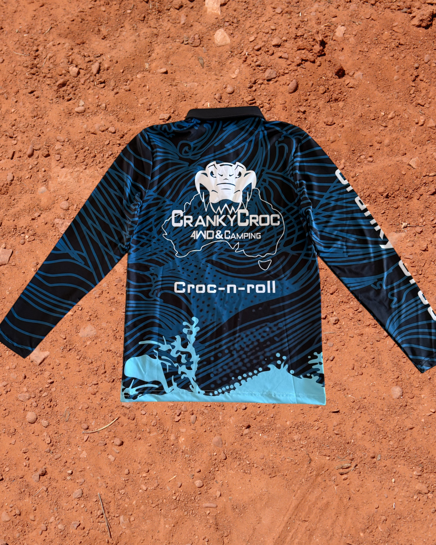 Blue kids long sleeve fishing shirt with 'Cranky Croc' branding on a red dirt background