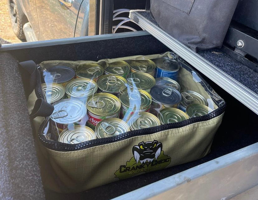 Canvas Clear Top Bag sitting in pullout camping draw. Clear top back is full of cooking ingredients.