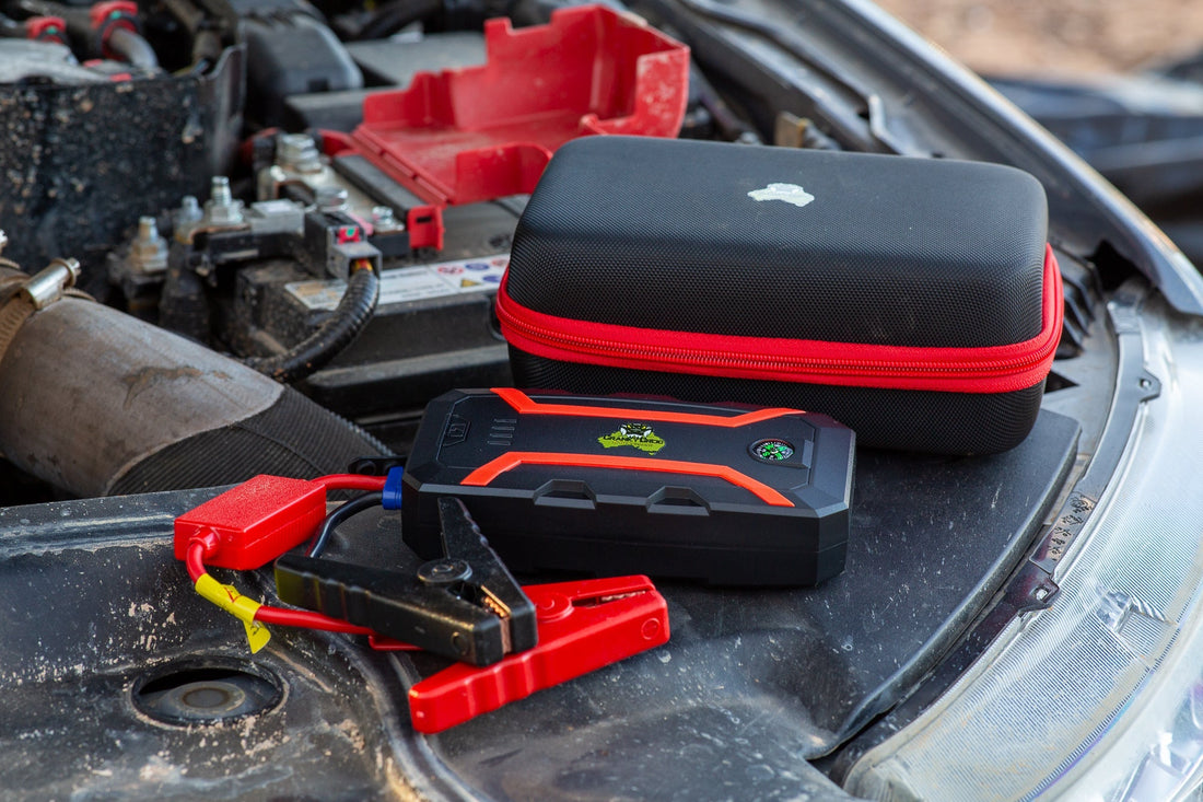 Portable Lithium Jump Starter with carry case sitting on 4WD engine. 