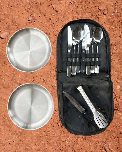 Camping Utensil Set for your camp kitchen. Set of silver cutlery and plates in a black carry case on a red dirt background.