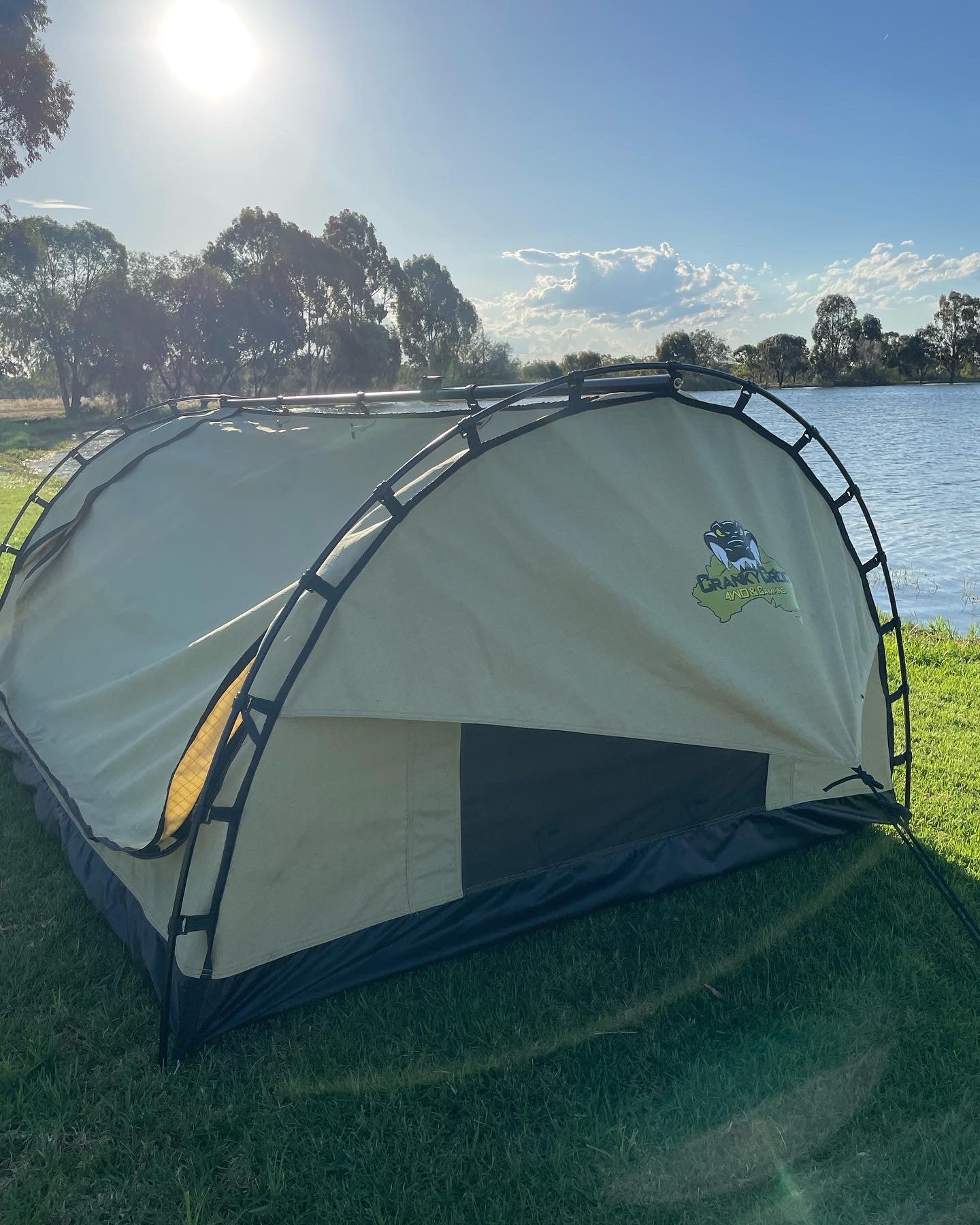 Dome double swag setup on grass next to lake