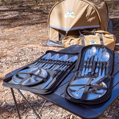 2 Person Camping Utensil Set for your camp kitchen. Utensil set of silver cutlery and plates in a black carrying case on a camping table. The image is set in Australian bushland.