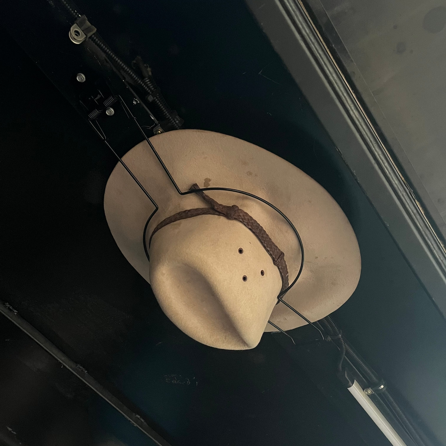 Cowboy hat holder holding an akubra in a black ute canopy