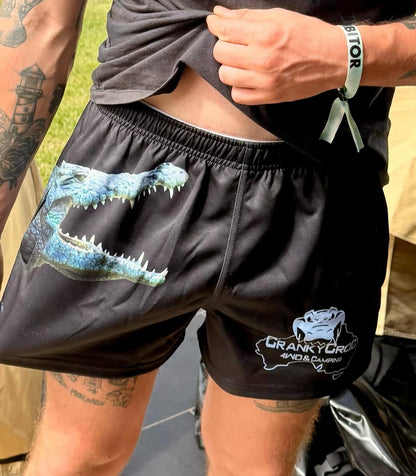 Person wearing black Aussie Footy Shorts with a crocodile graphic and 'Cranky Croc' branding.