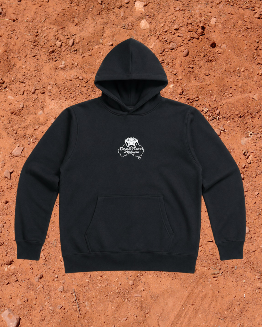 Front view of black hoodie with a white embroidered Cranky Croc logo on a red dirt background