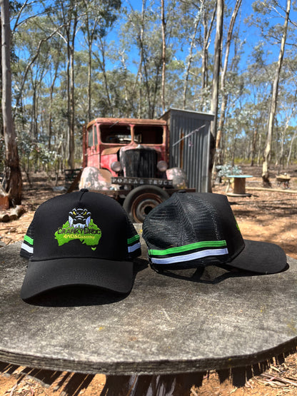 Two country trucker hats showing off the front and side. The country trucker hats are black, and also have a green and white stripe down the side. The black trucker hat  has a crocodile branding on the front