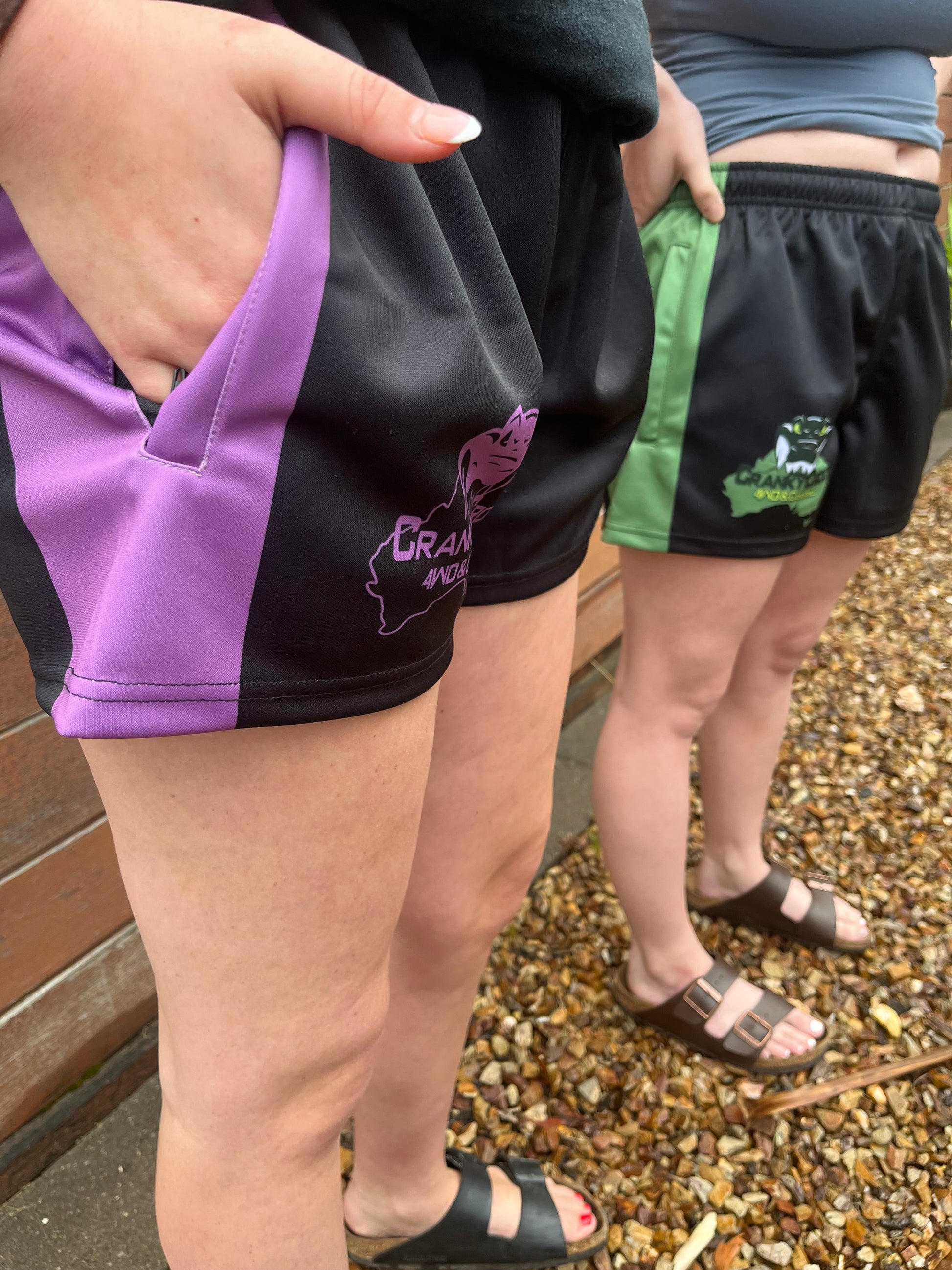 People wearing black with purple Footy Shorts and also black with green