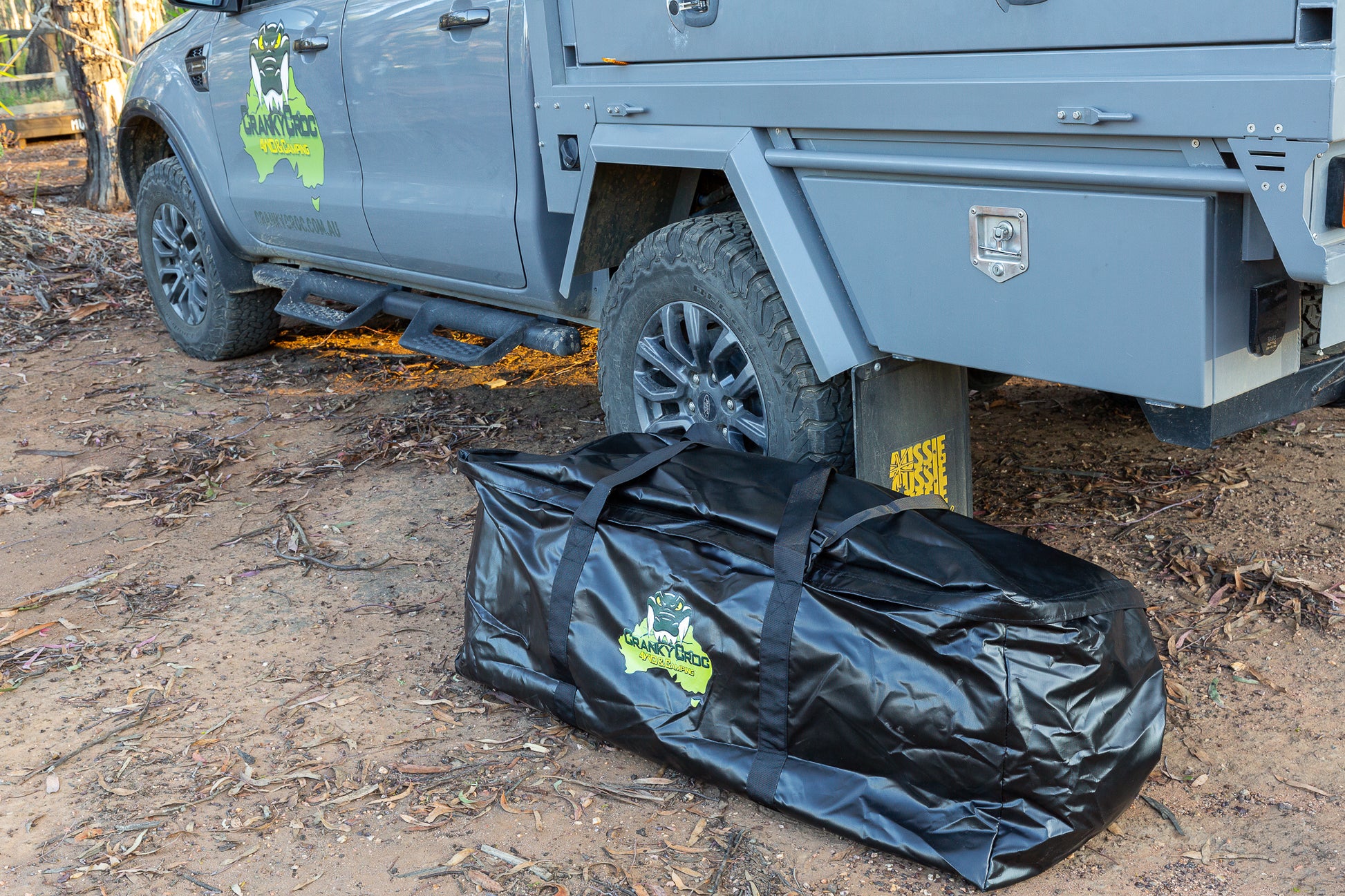 Swag bag or camping bag next to 4WD in the bush