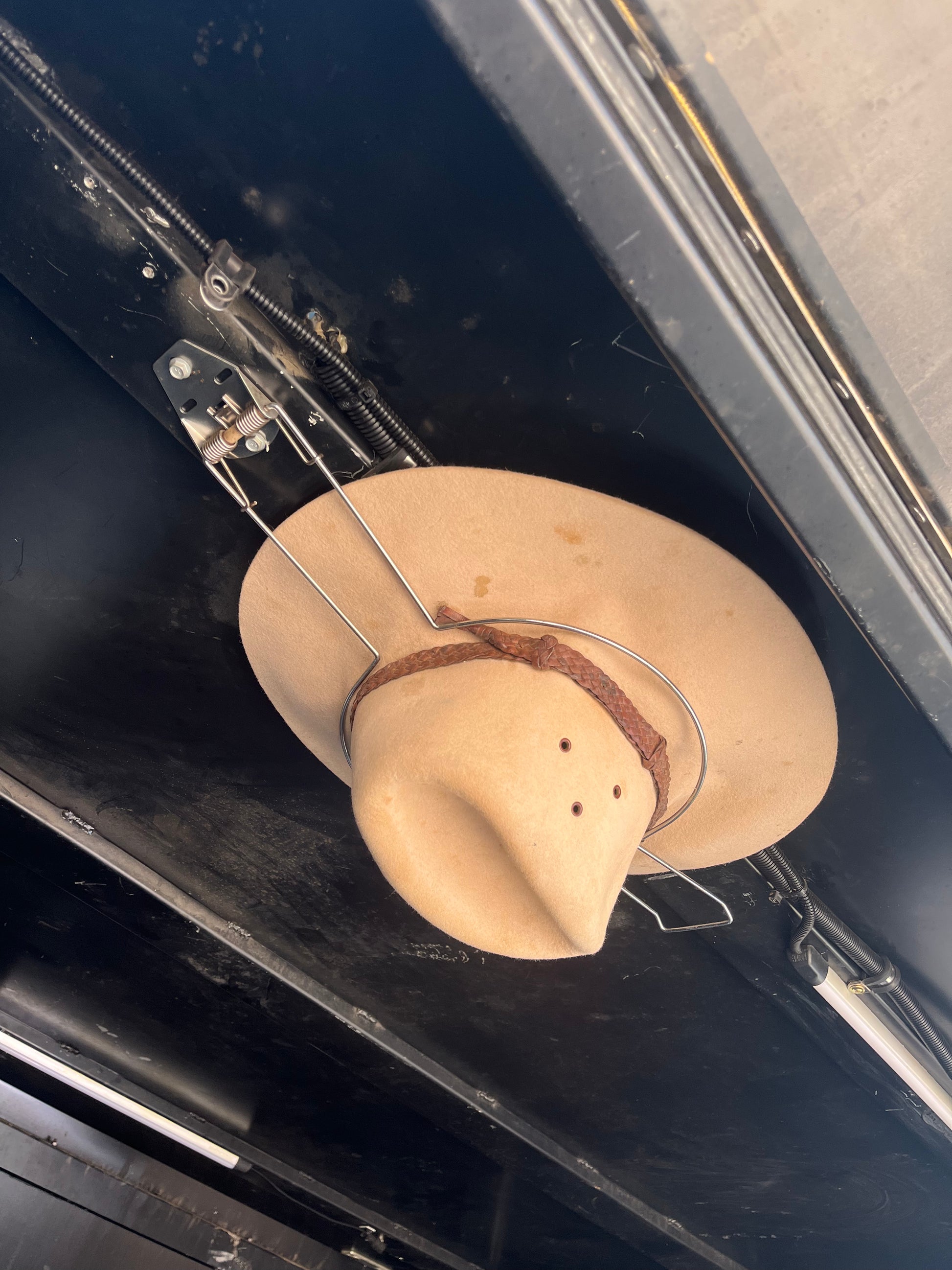 Cowboy hat holder holding an akubra in a black ute canopy