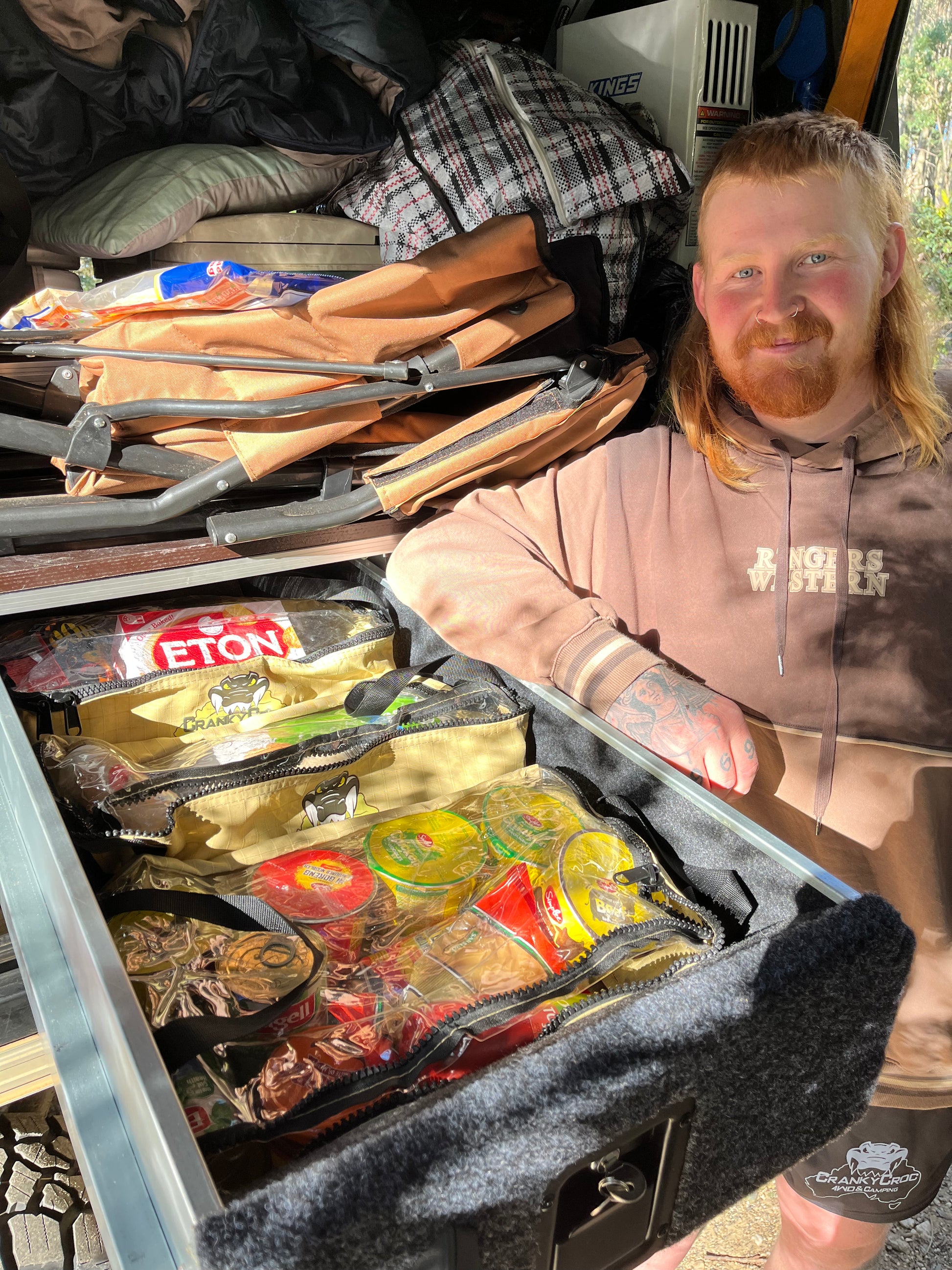Man standing next to a 4WD pull out draw with food supplies for camp kitchen