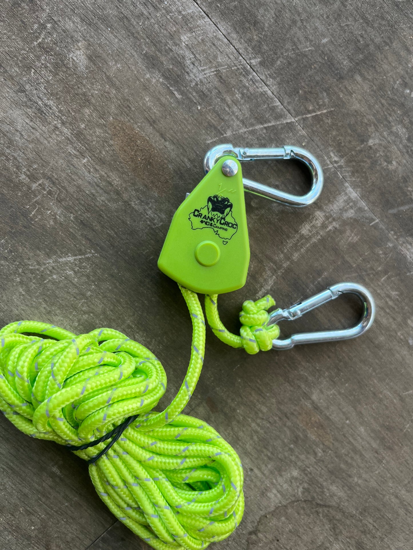 Cranky Croc branded tie down straps. The ratchet strap is on a timber background