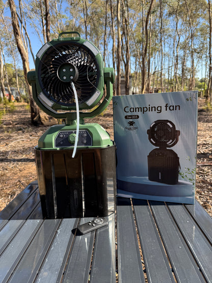 Cranky Croc misting fan. The camping fan is coloured green and is sitting on a camping table in bushland