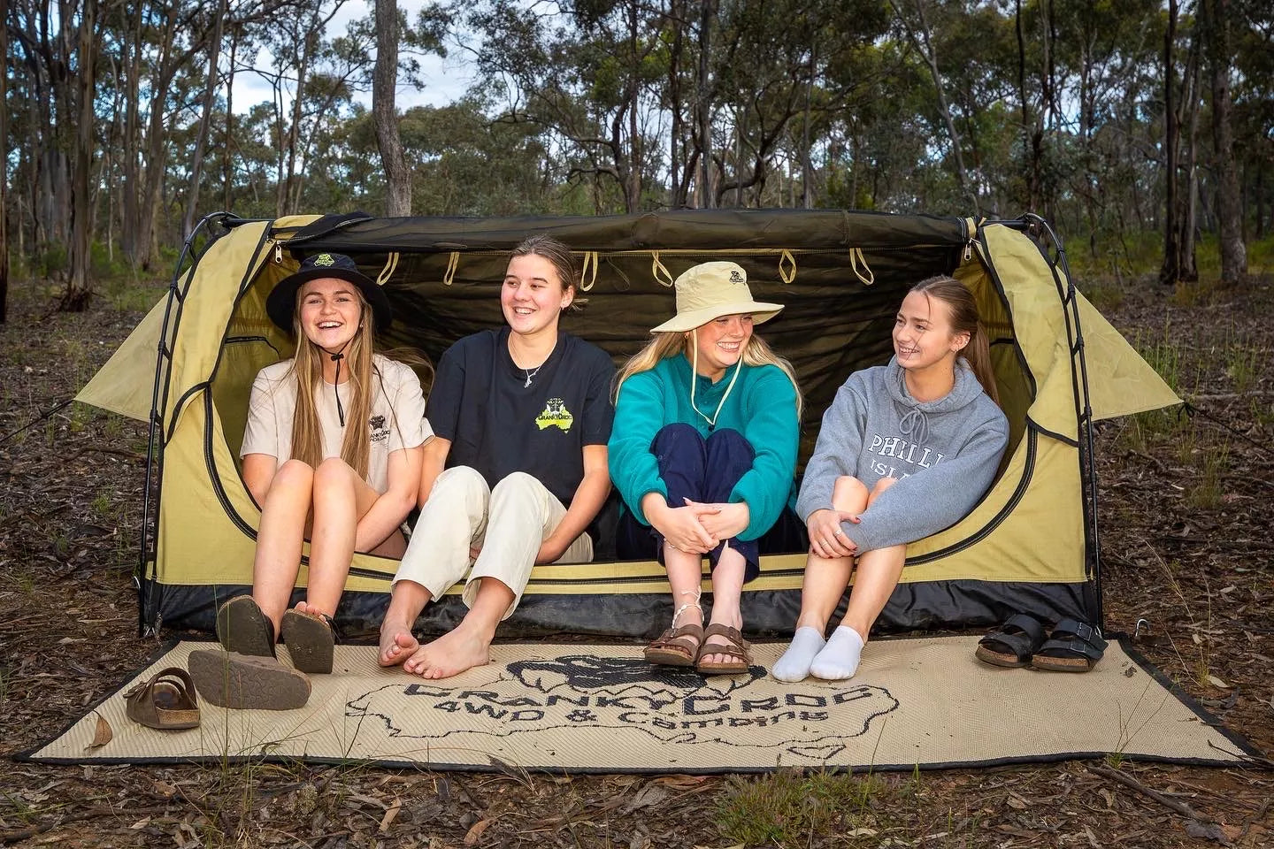 Four woman sitting in a Dome Swag laughing. The photo set in bushland