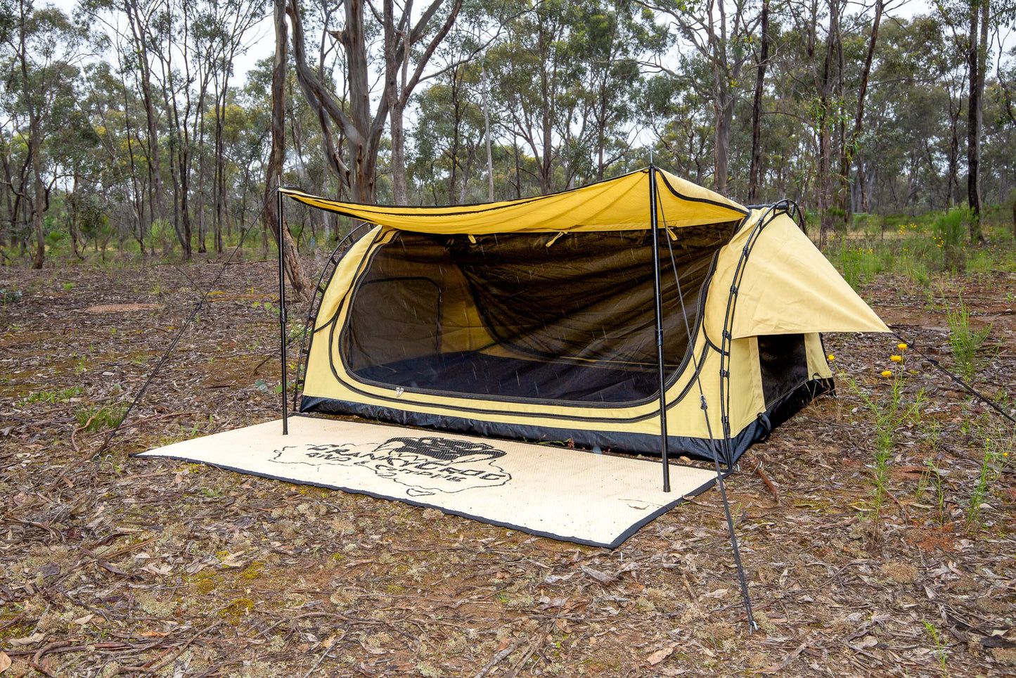 Dome swag with awning in the rain. The deluxe swag is set up in bushland.