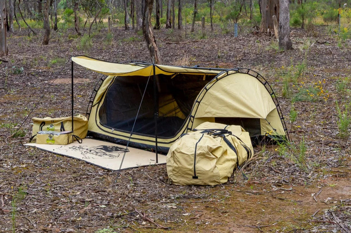 Camping deluxe swag and gear set up in a bushland 