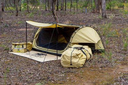 Camping deluxe swag and gear set up in a bushland 