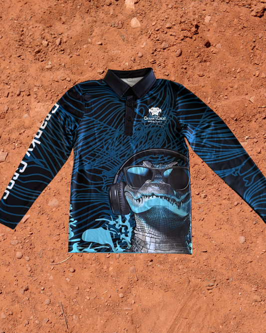 Blue kids long-sleeve fishing shirt with a crocodile design on a red dirt background