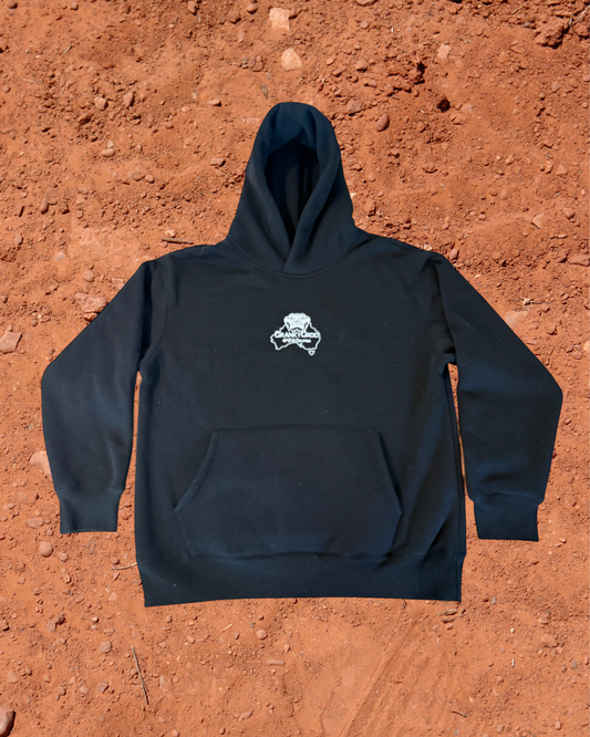 Front view of black hoodie with a white embroidered Cranky Croc logo on a red dirt background