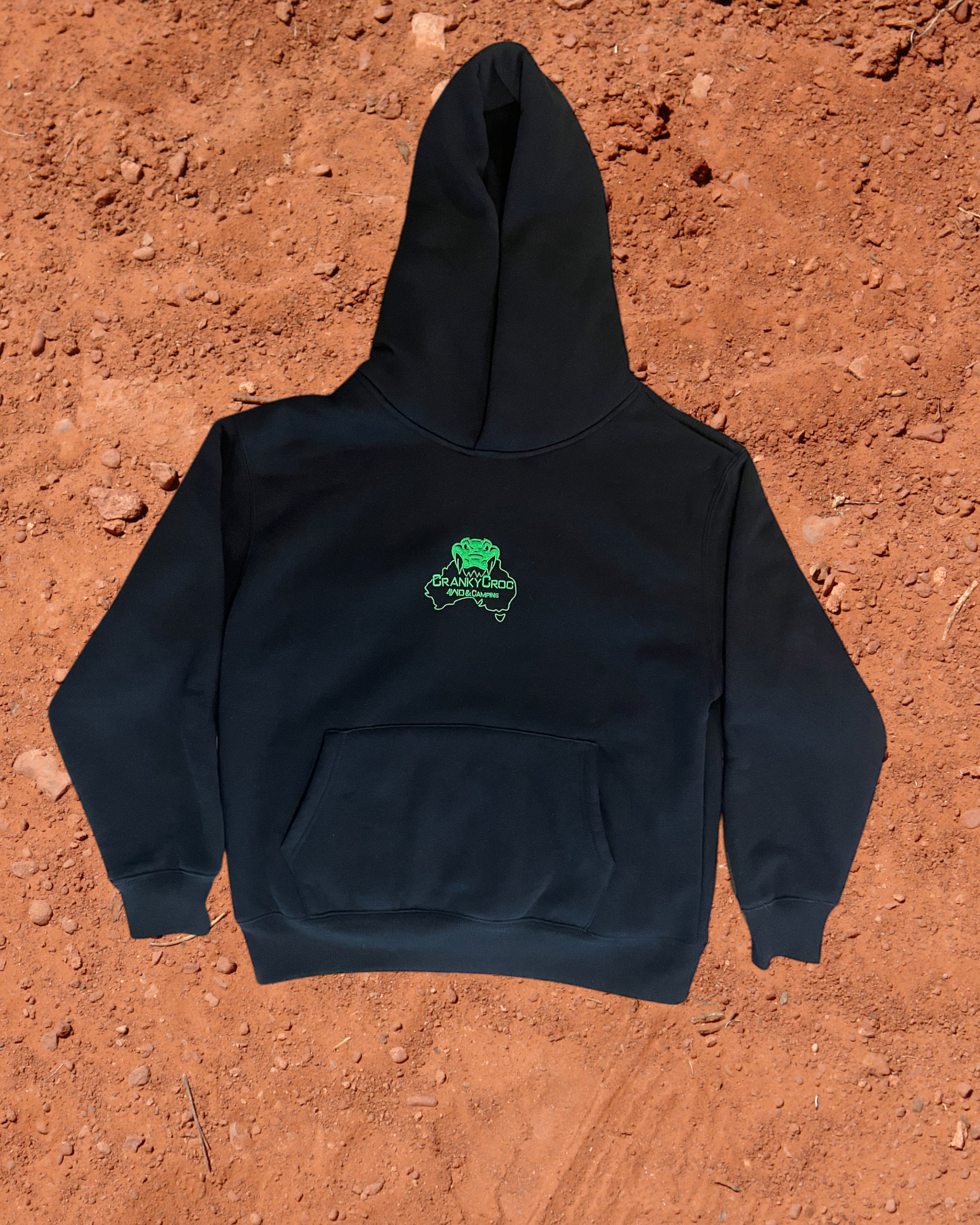 Front view of black hoodie with a green embroidered logo on a red dirt background