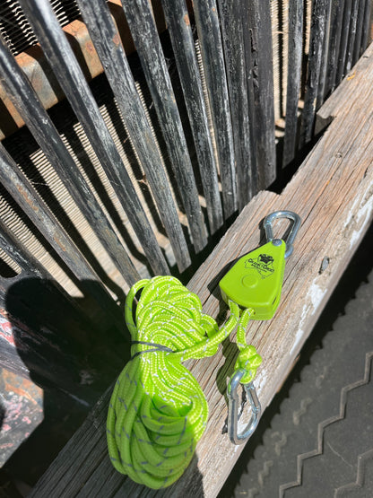 Green Cranky Croc branded tie down strap. The ratchet straps is on a timber