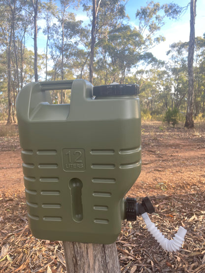 Water storage drum for camping with spout sitting on log