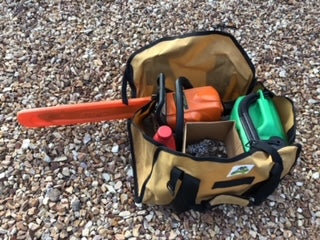 3-in-1 Wood Carry Bag on ground storing chainsaw, oil, fuel and spare chains for cutting up wood for camp fire