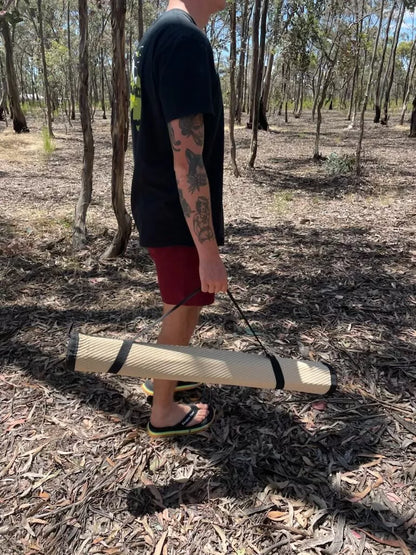 Person using the included elastic straps to easily carry Swag Mat.