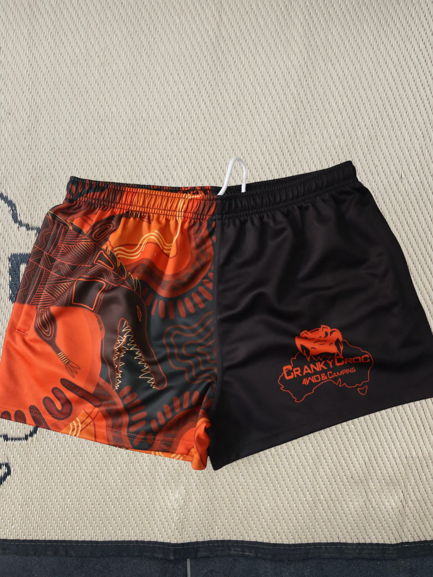 Pair of Aussie Footy Shorts, orange and black pattern, logo