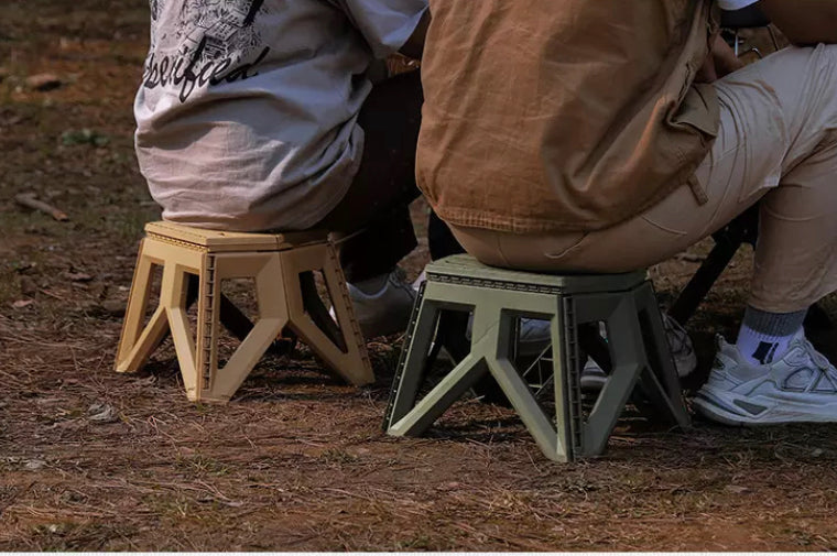 Two people sitting on two Quickie Folding Steps camping in bushland.