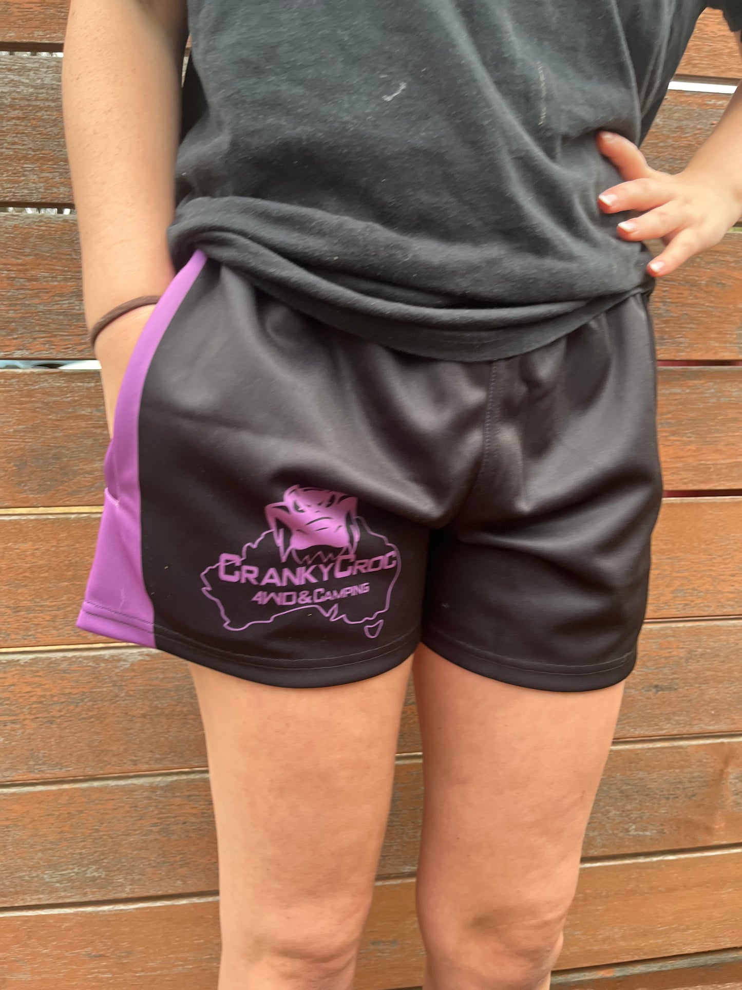 Person wearing black with purple Aussie Footy Shorts