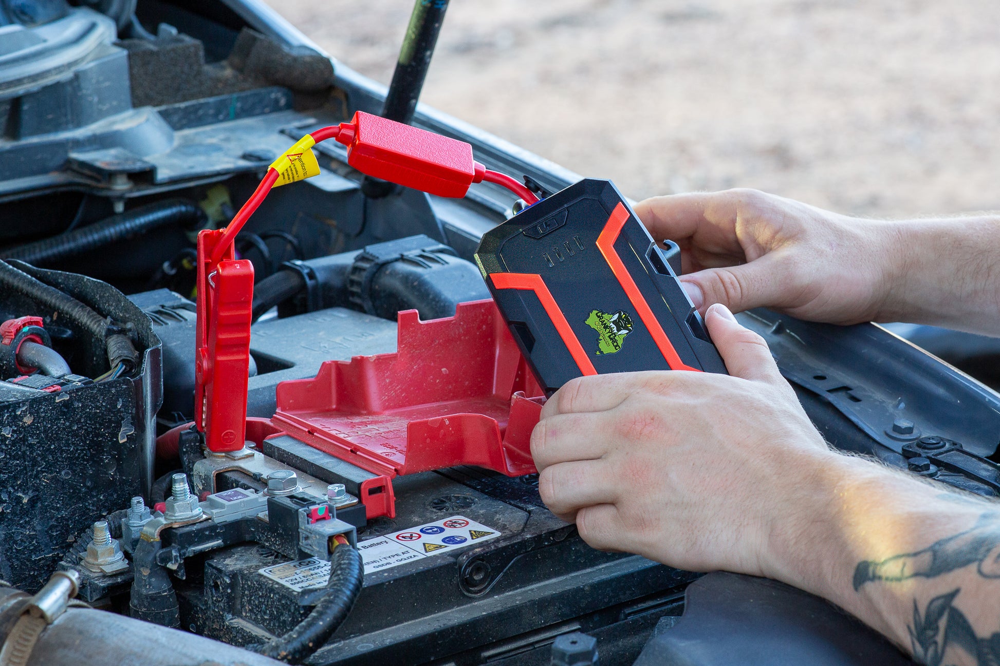 Man jump starts 4WD using Jump Starter, battery jump starter is Cranky Croc branded