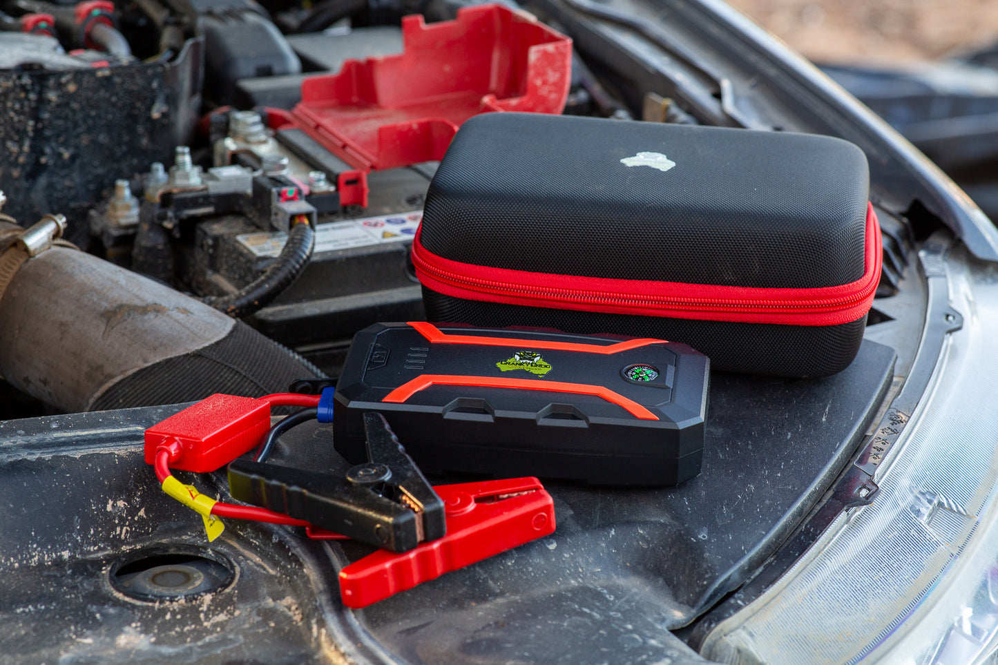 Jump Starter with protective case sitting on 4WD engine, battery jump starter is Cranky Croc branded