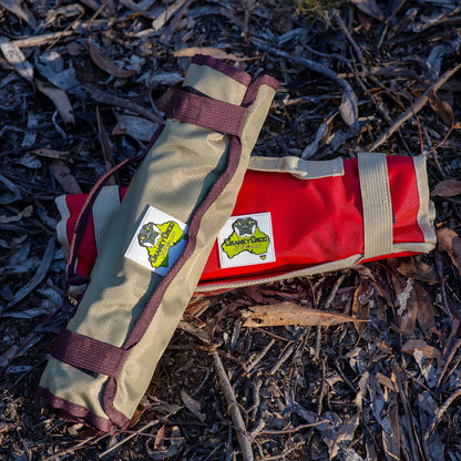 Two rolled packs of screw in tent and swag pegs on ground in bushland