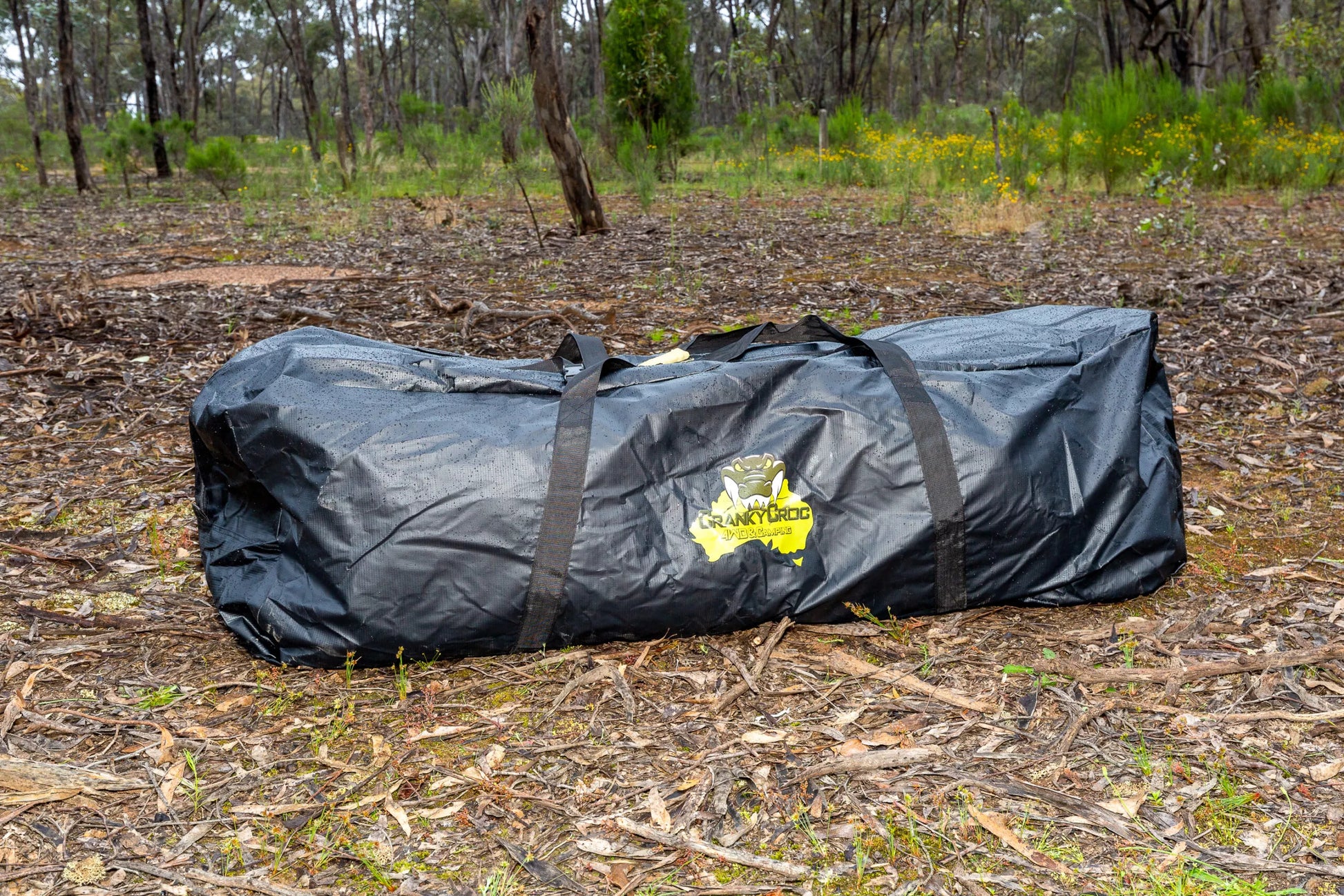 Black PVC swag bag for double swag sitting in bushland