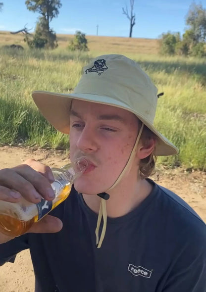 Young man wearing a Folding Pouch Hat while drinking a beer